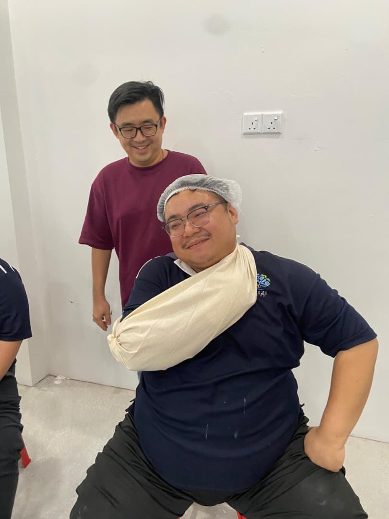 Dr Orizi employees practising an arm sling during First Aid and CPR training