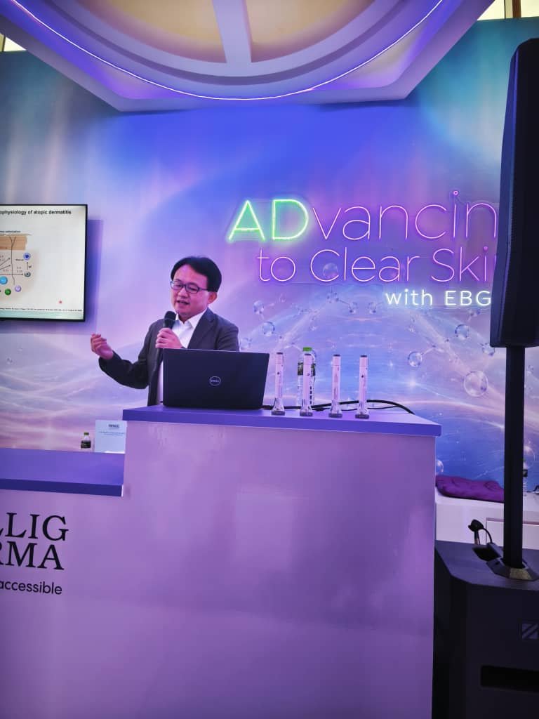 Speaker presenting on the pathophysiology of atopic dermatitis at PDM ADC 2026