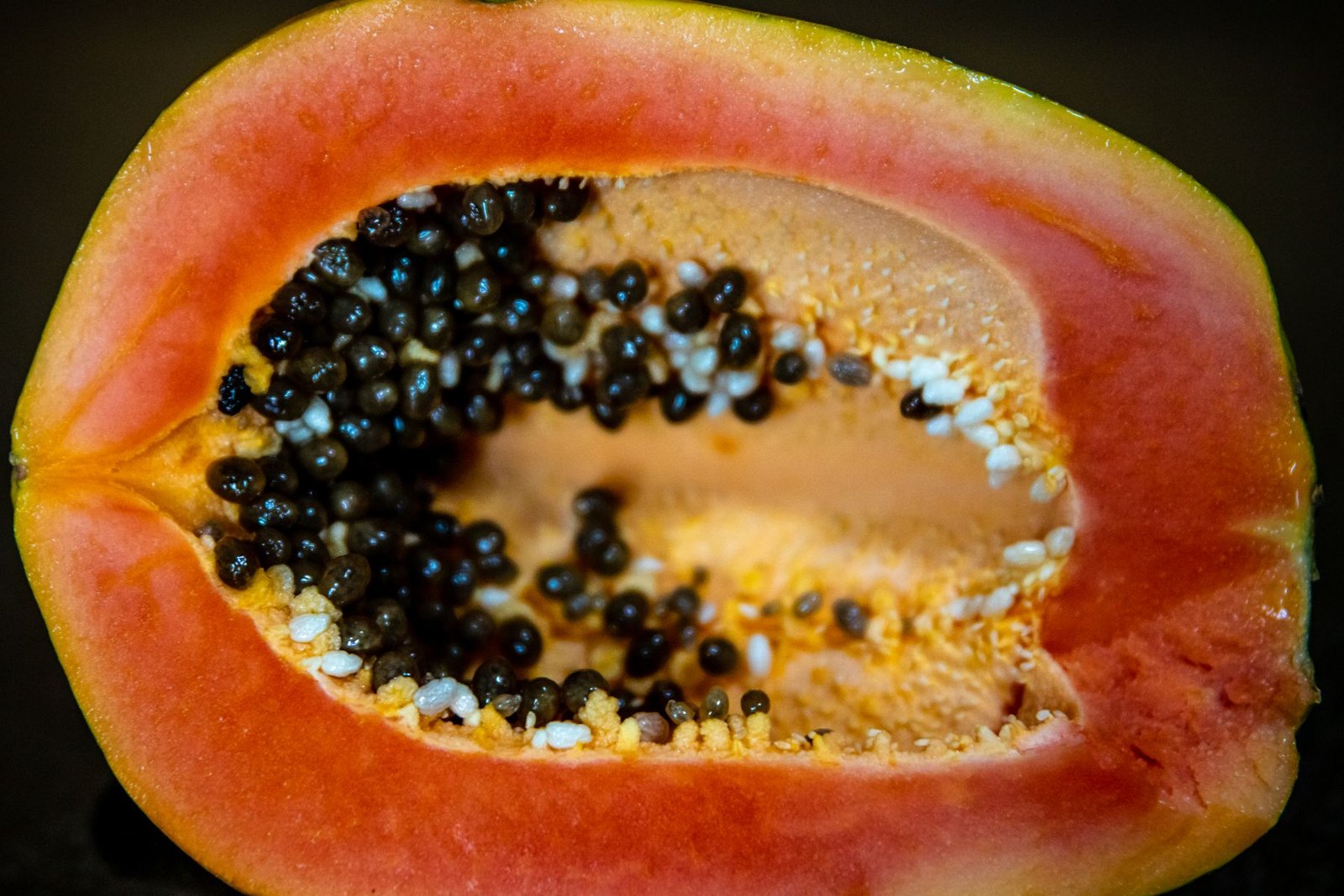 A ripe papaya cut in half showing orange flesh and black seeds, one of the three fruits used as a plant exosome source