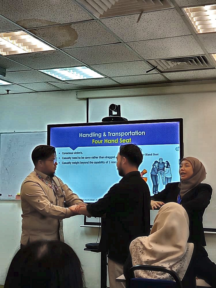 Practising the four-hand seat casualty carry during first aid training